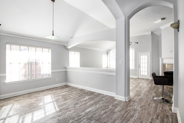 unfurnished room featuring ornamental molding, vaulted ceiling, and hardwood / wood-style floors