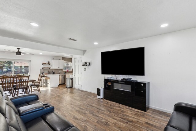 living room with dark hardwood / wood-style floors and ceiling fan