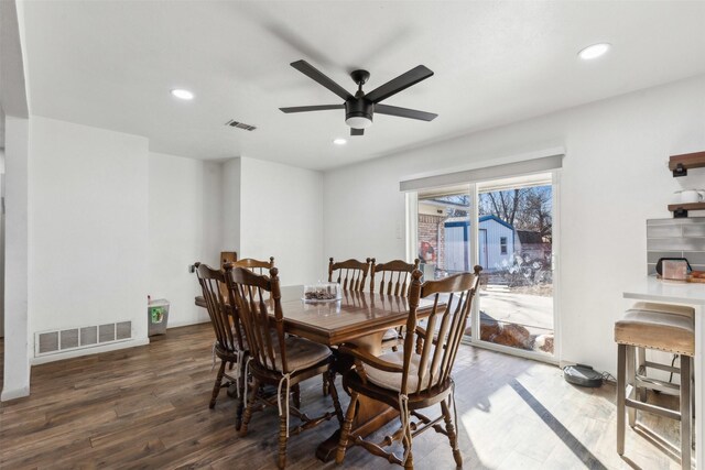 dining area with dark wood-type flooring and ceiling fan