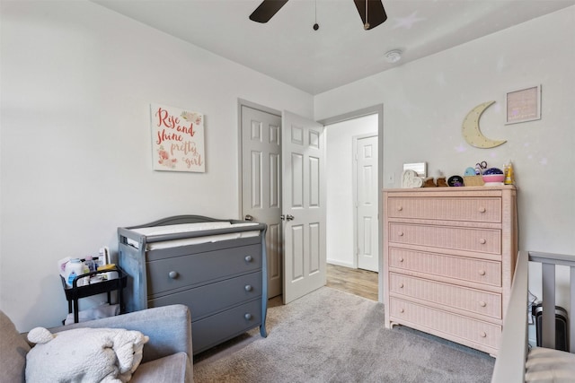 living area featuring light colored carpet and ceiling fan