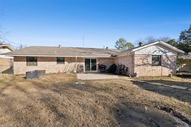 back of house featuring a lawn and a patio area