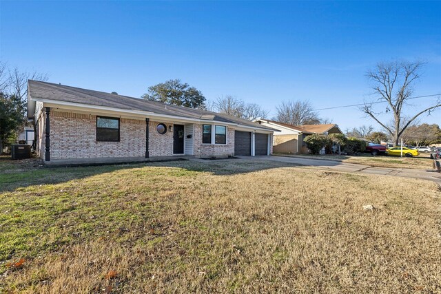 ranch-style house with a garage, cooling unit, and a front lawn