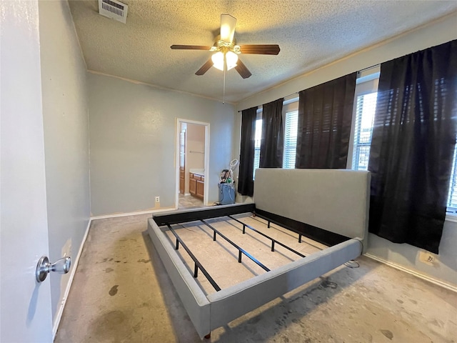 bedroom with ceiling fan, connected bathroom, and a textured ceiling