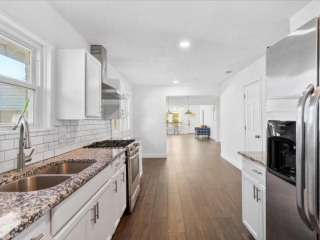 kitchen with stainless steel appliances, sink, white cabinets, and light stone counters