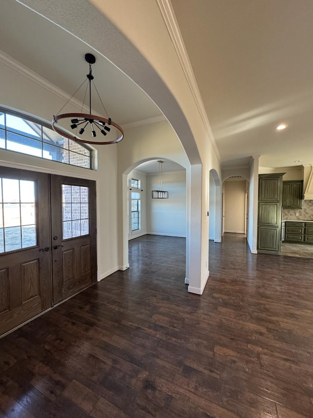 foyer entrance featuring crown molding, plenty of natural light, dark hardwood / wood-style floors, and french doors