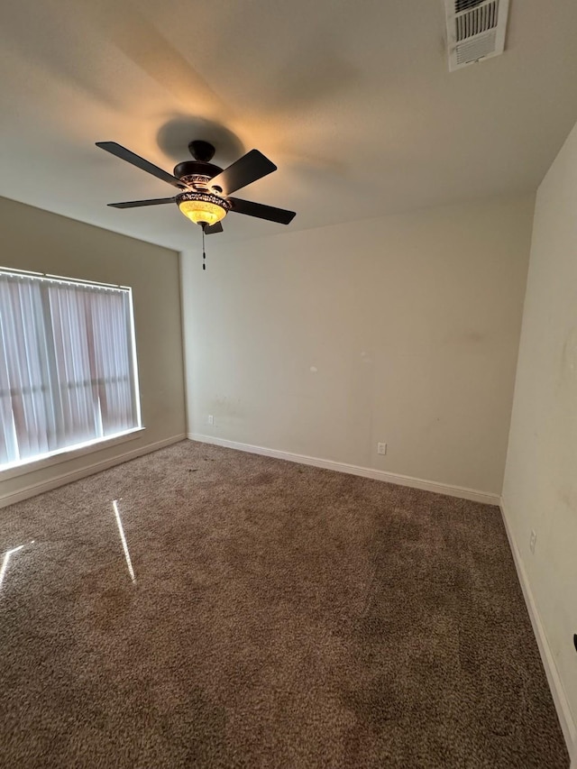 carpeted spare room featuring ceiling fan