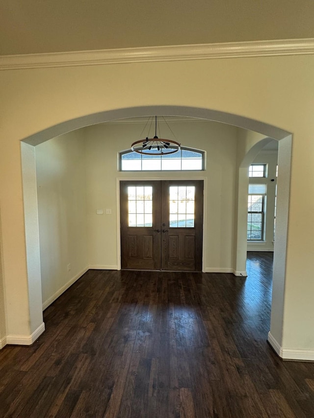 foyer featuring crown molding and dark wood-type flooring