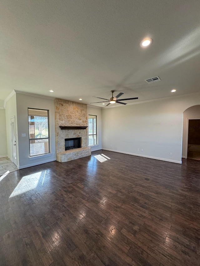 unfurnished living room featuring dark wood-type flooring, a fireplace, and a healthy amount of sunlight