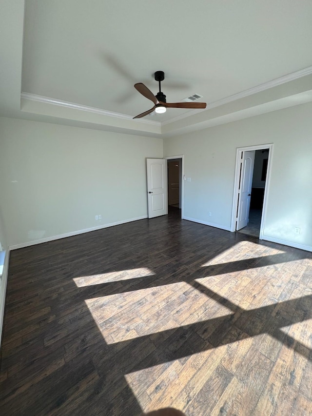 unfurnished bedroom featuring ceiling fan, a tray ceiling, and dark hardwood / wood-style flooring