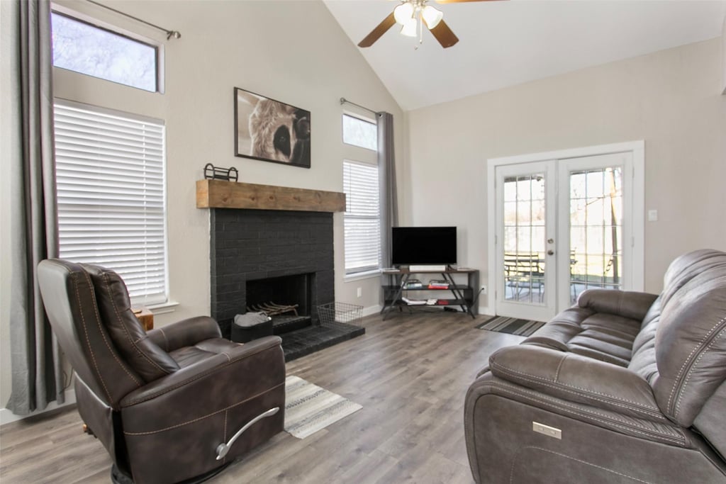 living room featuring french doors, high vaulted ceiling, a healthy amount of sunlight, and light hardwood / wood-style floors