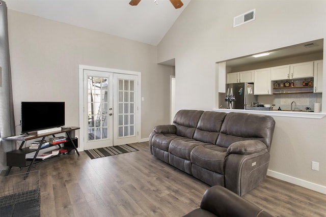 living room featuring dark wood-type flooring, high vaulted ceiling, french doors, and ceiling fan