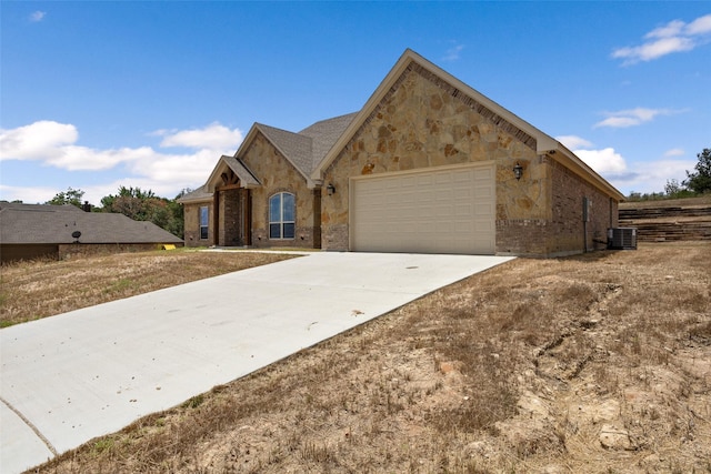 view of front of property featuring a garage and cooling unit