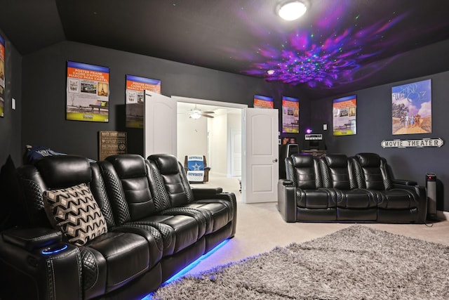 carpeted home theater with vaulted ceiling and ceiling fan