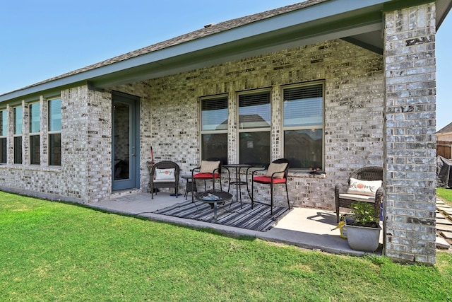 rear view of property with a yard and a patio area