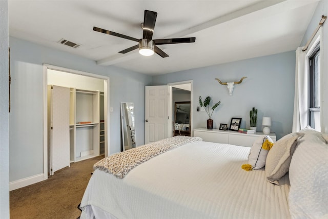 bedroom featuring a closet, visible vents, dark carpet, a spacious closet, and ceiling fan