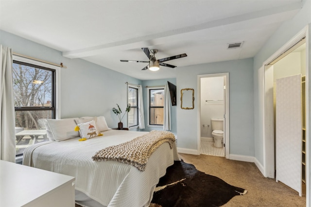 bedroom featuring baseboards, visible vents, a ceiling fan, light colored carpet, and ensuite bath