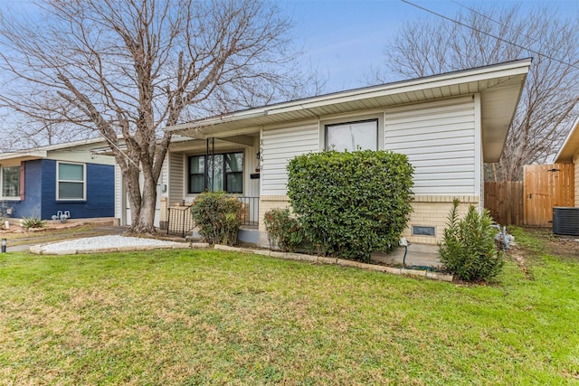 ranch-style home with cooling unit, brick siding, fence, and a front lawn