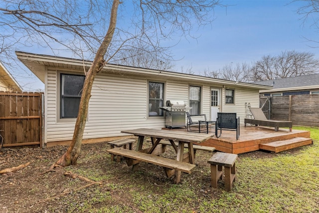 back of property featuring a wooden deck and fence