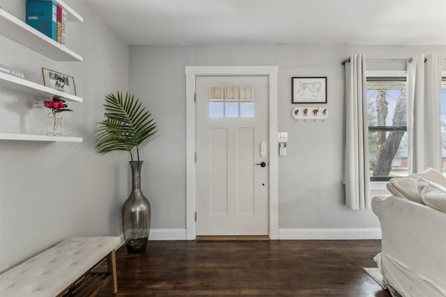 entrance foyer with dark wood-type flooring and baseboards