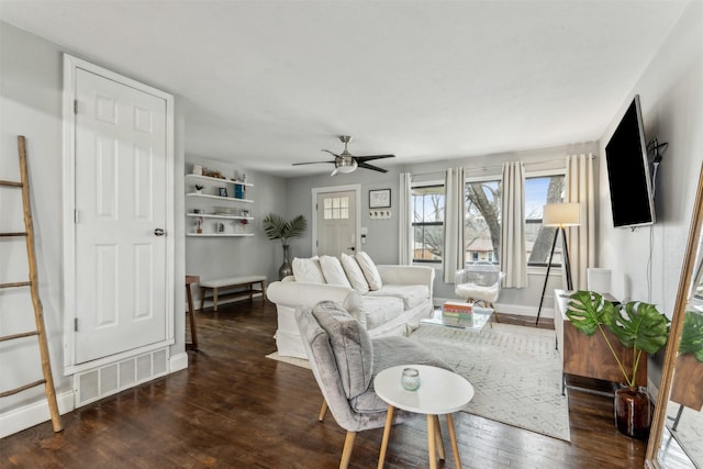 living area featuring dark wood-style floors, visible vents, ceiling fan, and baseboards