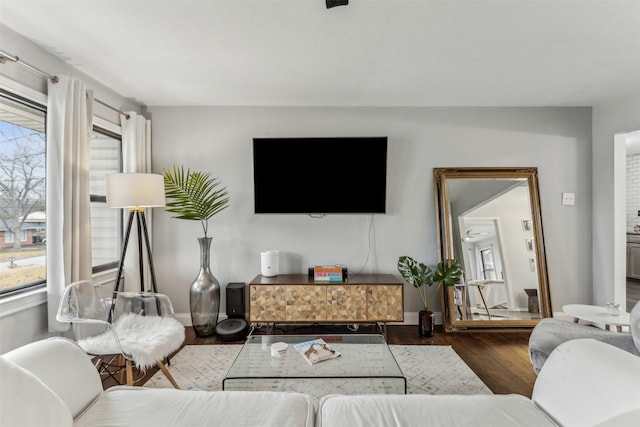 living area featuring baseboards and dark wood finished floors