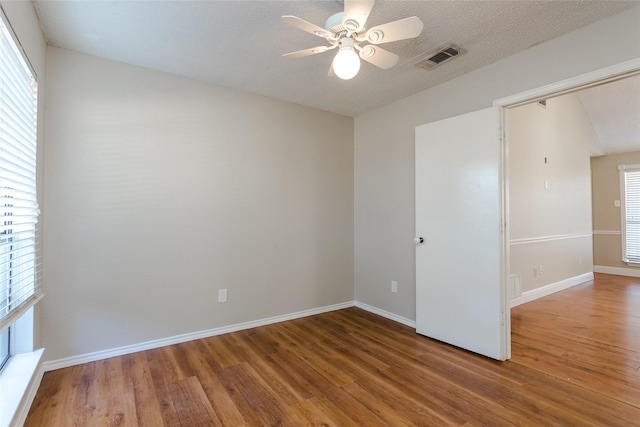 spare room with ceiling fan, hardwood / wood-style floors, and a textured ceiling