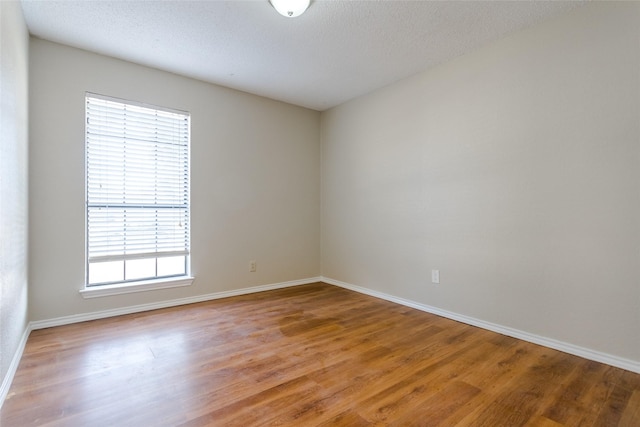 spare room featuring hardwood / wood-style flooring and a textured ceiling