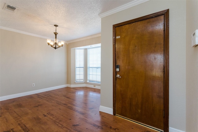 entryway with ornamental molding, a chandelier, hardwood / wood-style floors, and a textured ceiling