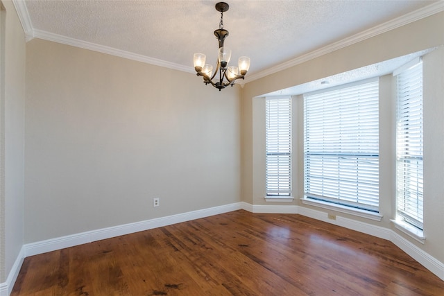 empty room with hardwood / wood-style flooring, ornamental molding, a chandelier, and a textured ceiling