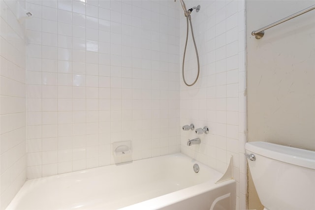 bathroom featuring tiled shower / bath combo and toilet