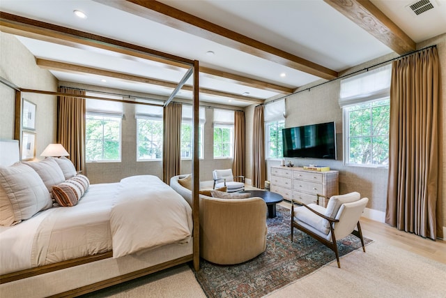 bedroom featuring light wood-type flooring and beam ceiling