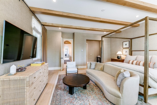 bedroom with beam ceiling and light wood-type flooring