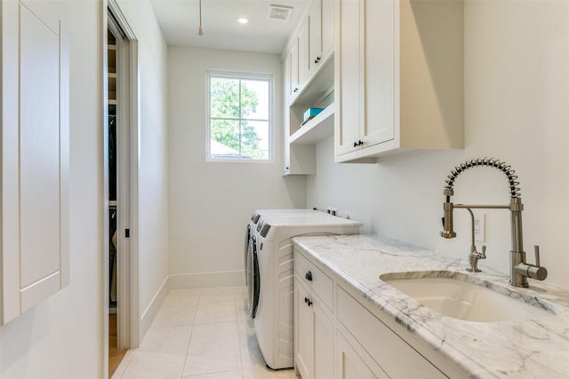 laundry room with separate washer and dryer, sink, light tile patterned floors, and cabinets