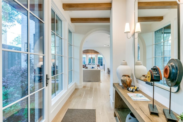 hallway with beam ceiling and light wood-type flooring