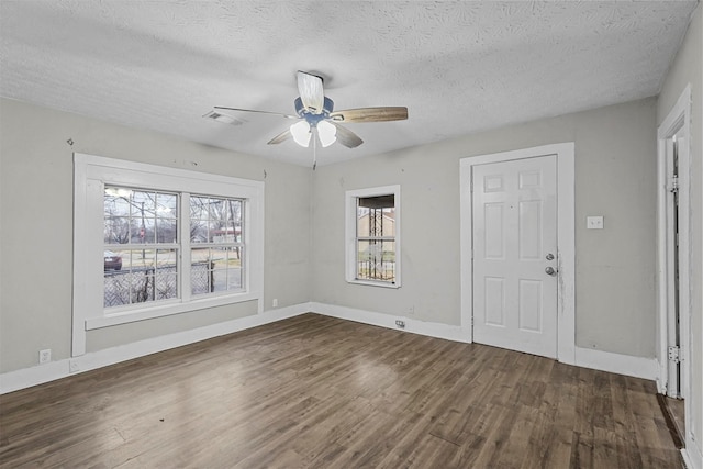 unfurnished room featuring dark hardwood / wood-style flooring, a textured ceiling, and ceiling fan