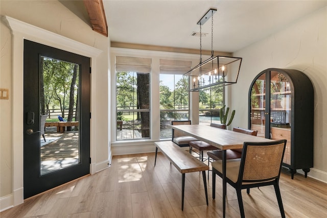 dining area with a notable chandelier and light hardwood / wood-style floors