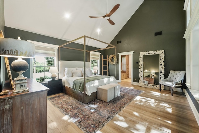 bedroom with high vaulted ceiling and hardwood / wood-style floors