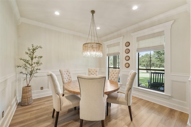 dining room with an inviting chandelier, crown molding, and light hardwood / wood-style floors