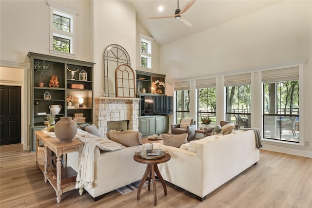 living room featuring light hardwood / wood-style flooring, a fireplace, and a healthy amount of sunlight