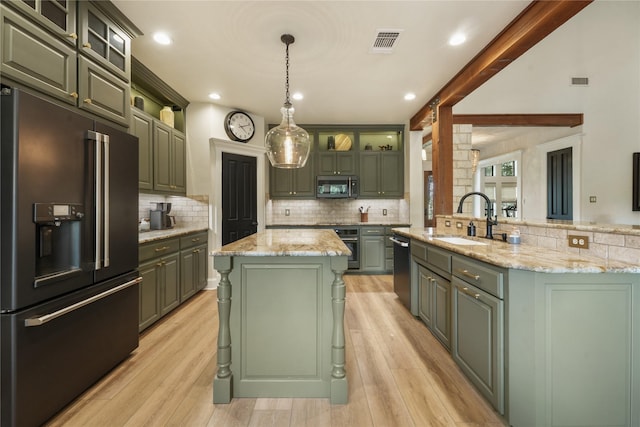 kitchen featuring a center island, appliances with stainless steel finishes, sink, and green cabinets