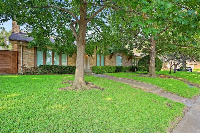 view of property hidden behind natural elements featuring a front yard