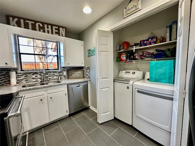 laundry area with separate washer and dryer and sink