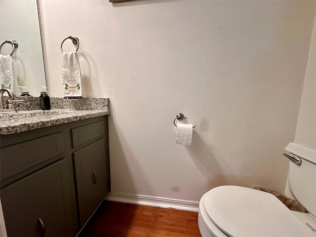 bathroom featuring hardwood / wood-style flooring, vanity, and toilet