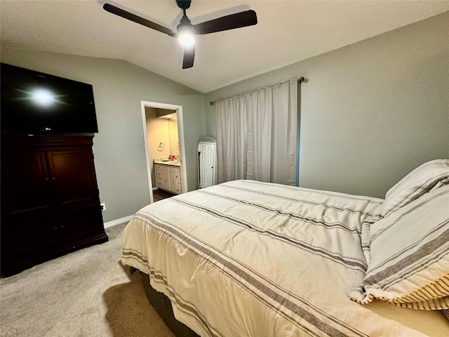 carpeted bedroom featuring vaulted ceiling, ensuite bathroom, and ceiling fan