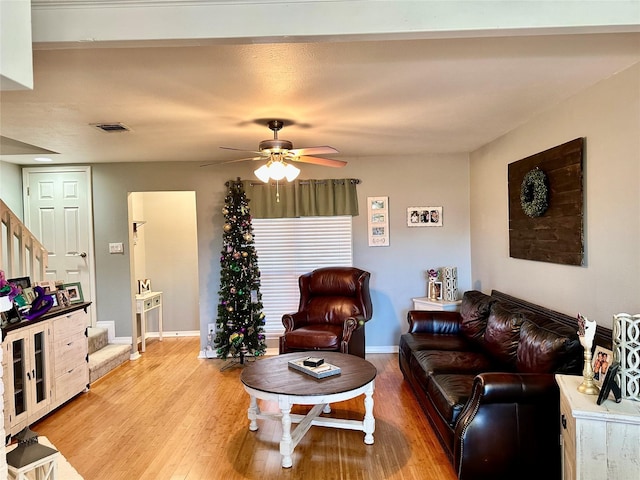 living room featuring light hardwood / wood-style flooring and ceiling fan