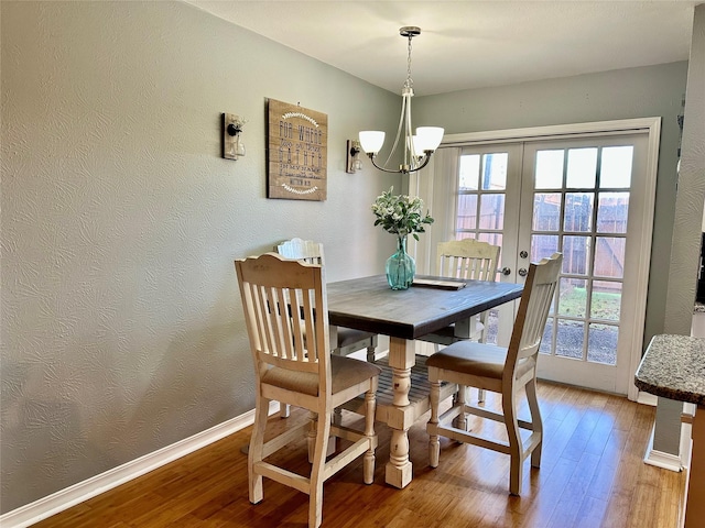 dining space featuring wood-type flooring, french doors, and a healthy amount of sunlight