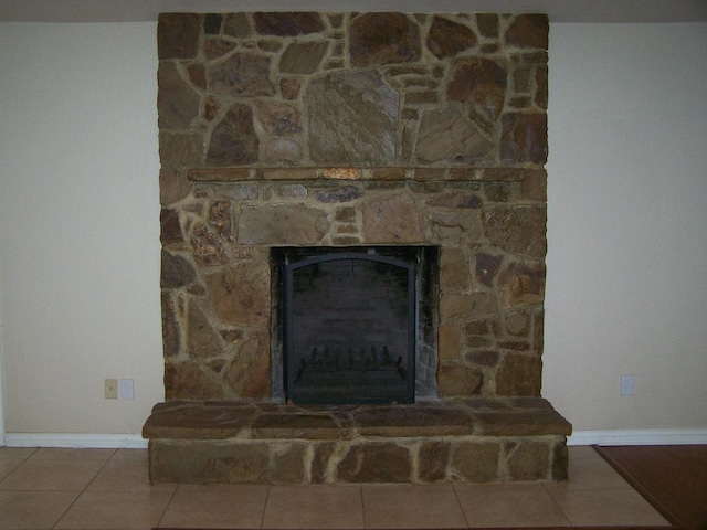 details with a stone fireplace and baseboards