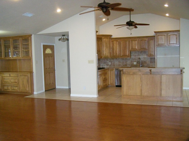 kitchen featuring light wood-style floors, a kitchen island, dishwasher, and vaulted ceiling