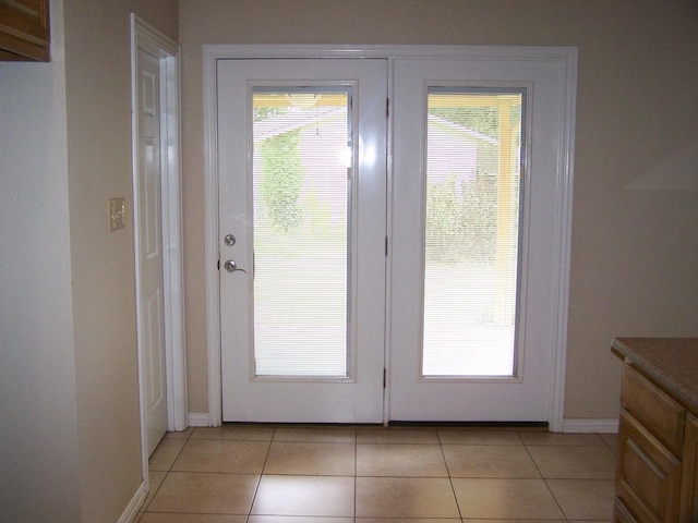 doorway to outside with light tile patterned floors, french doors, and baseboards