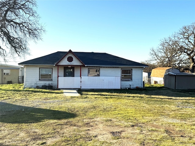 single story home featuring a storage shed and a front lawn